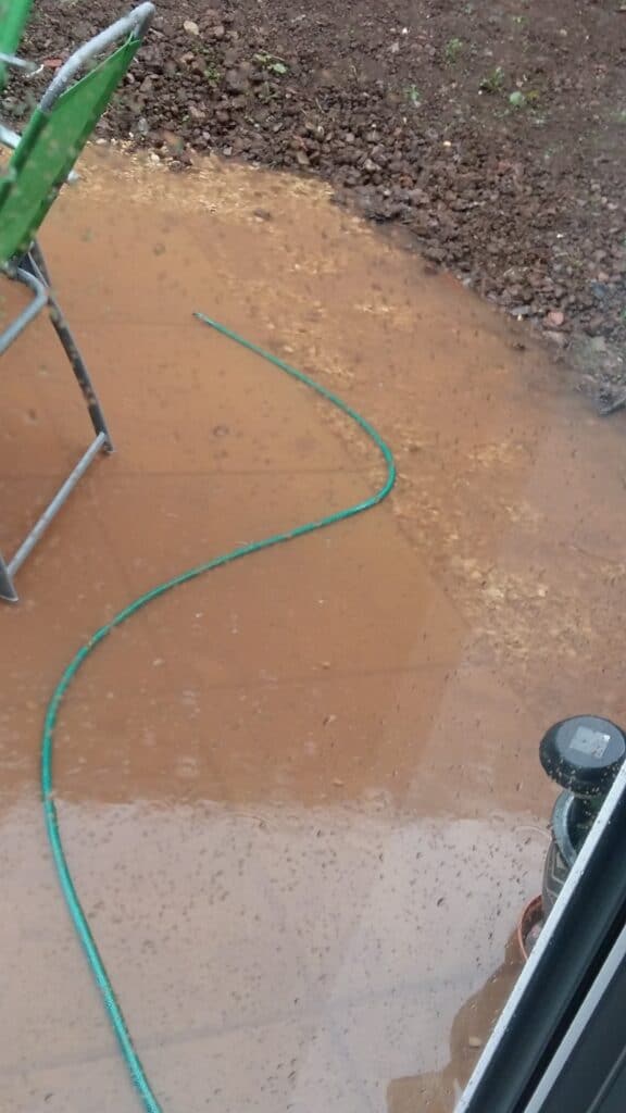 A flooded patio area due to improper drainage provision