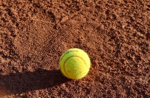 Tennis ball sitting on dirt