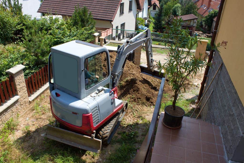 A mini excavator in someones backyard