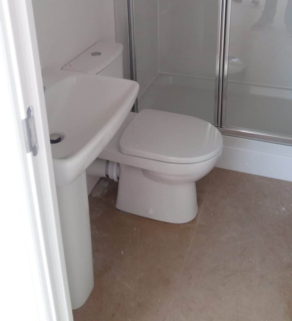 A new construction home with a basic basin and toilet but without flooring
