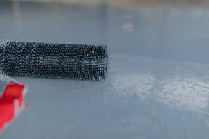 A close up view of a bumpy epoxy floor with a needle roller
