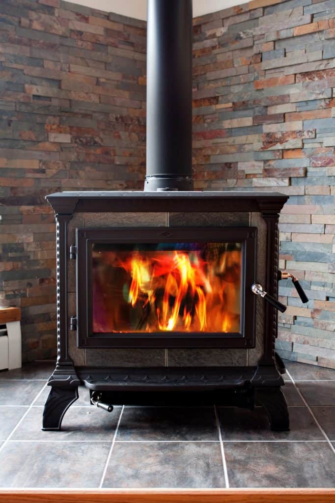 Burning Cast Iron Wood Stove Heating with tiles on the wall and floor