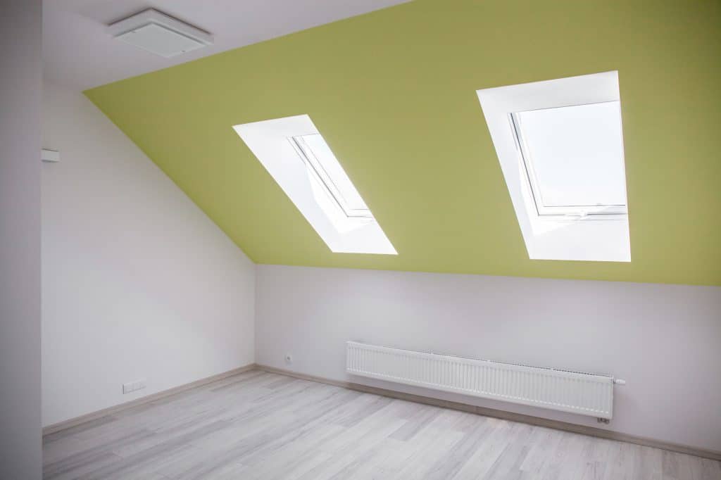 An empty room with slanted roof and rooflights