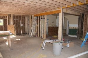 Various construction work being done in a room with plywood floors