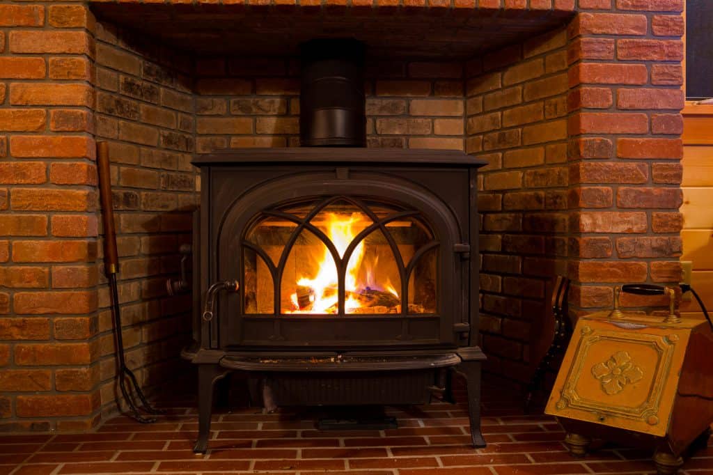 A lit wood stove with fire burning
